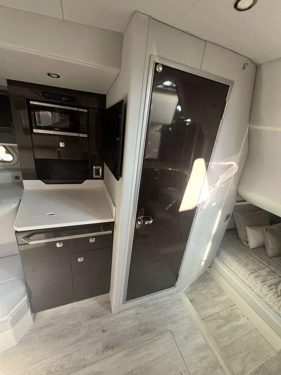 Slide: The Image of 2022 Formula 400 Super Sport Crossover interior with modern kitchen and cozy sleeping area. - 49