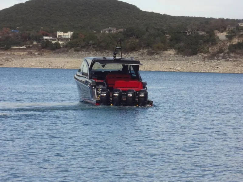 Slide: The Image of 2022 Formula 400 Super Sport Crossover boat cruising on a lake with scenic background. - 5