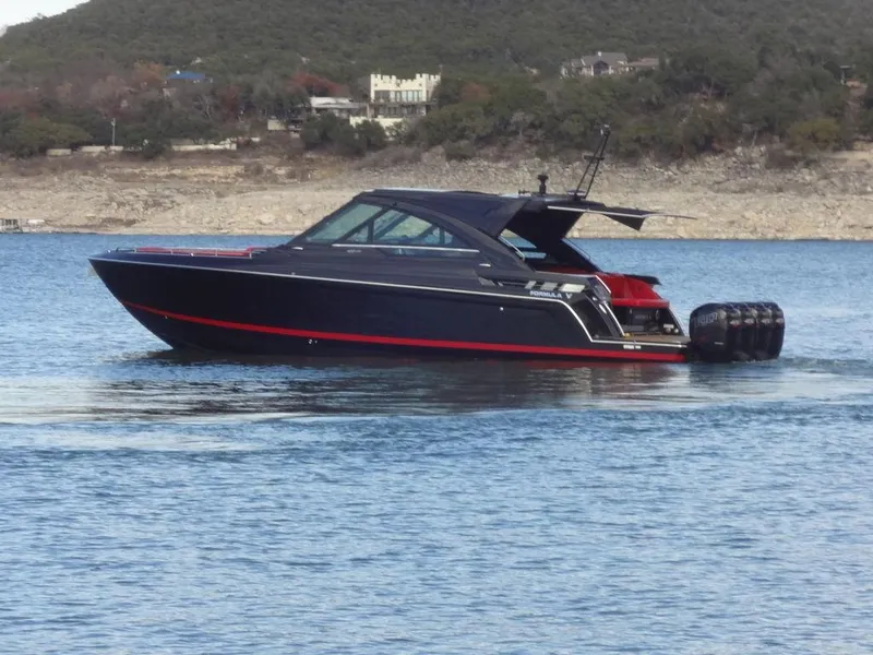 Slide: The Image of 2022 Formula 400 Super Sport Crossover boat on a lake with scenic background. - 6