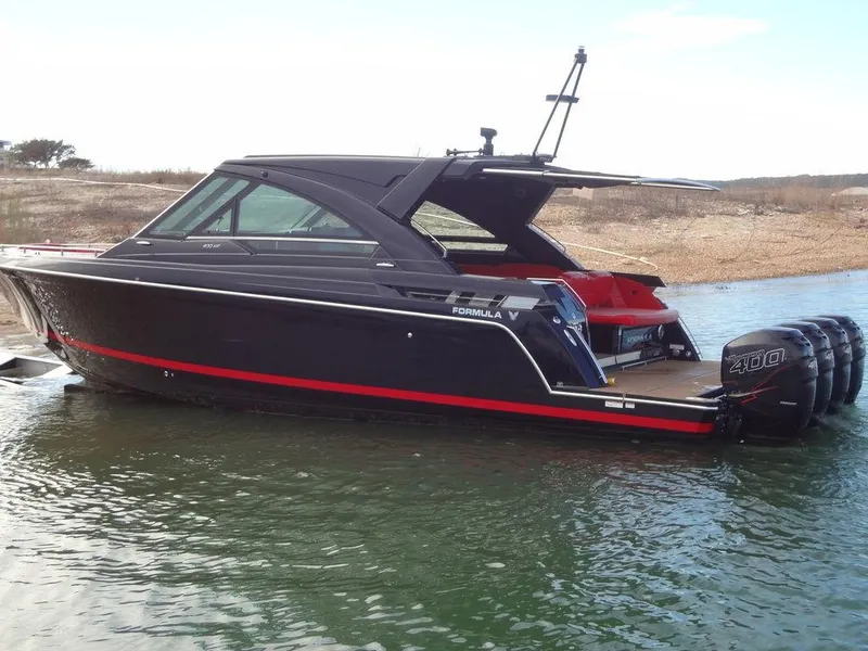 Slide: The Image of 2022 Formula 400 Super Sport Crossover boat with sleek black design on water. - 7