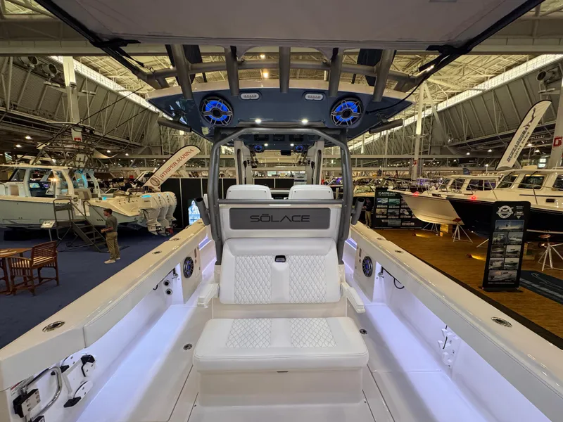 Slide: The Image of 2025 Solace 32 CS boat interior at a boat show, featuring modern seating and design. - 10