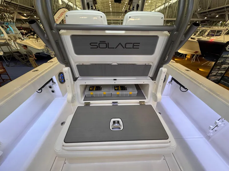 Slide: The Image of Solace 32 CS 2025 boat interior with storage compartment open at a boat show. - 12