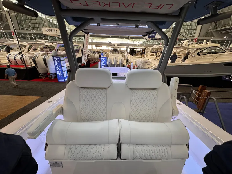 Slide: The Image of 2025 Solace 32 CS boat interior with luxurious white seating at a boat show. - 14