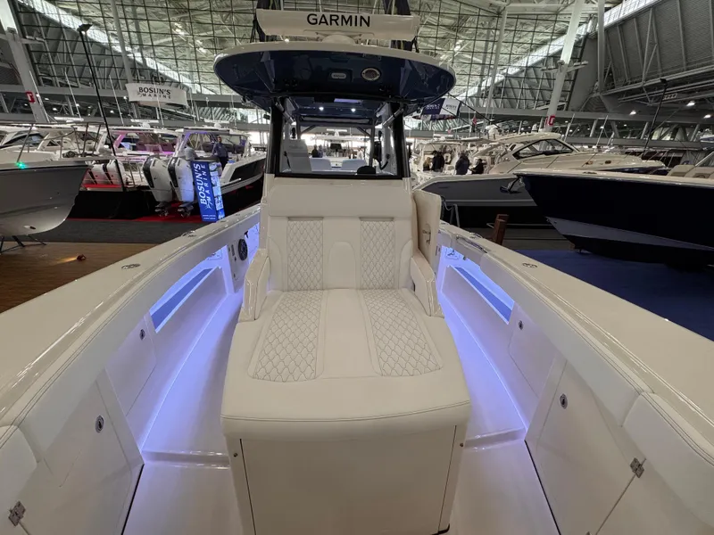 Slide: The Image of 2025 Solace 32 CS boat interior with modern seating and ambient lighting at a boat show. - 17