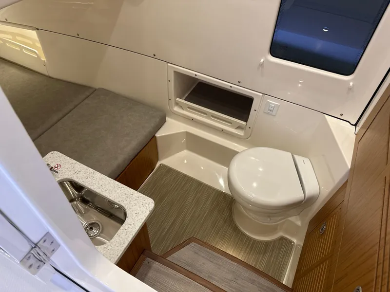Slide: The Image of 2025 Solace 32 CS boat interior with compact bathroom and seating area. - 19