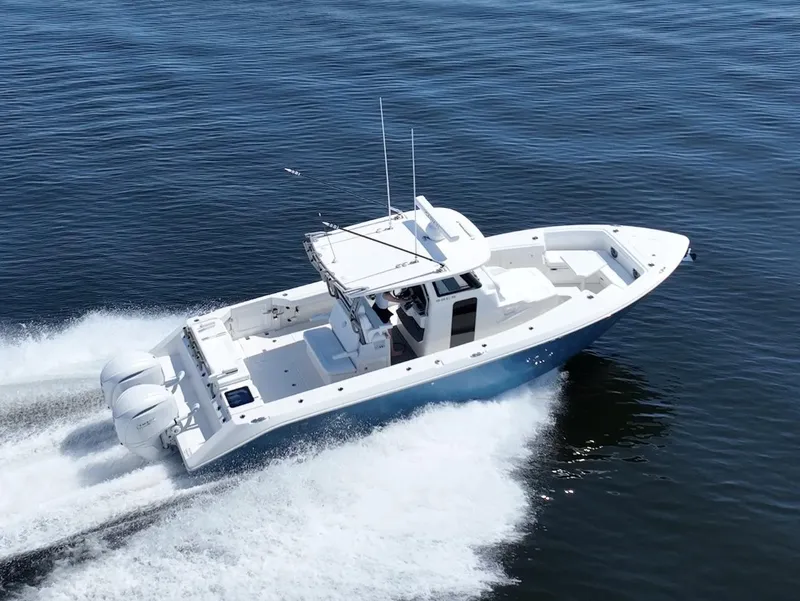 Slide: The Image of 2025 Solace 32 CS boat cruising on open water, showcasing sleek design and powerful engines. - 5