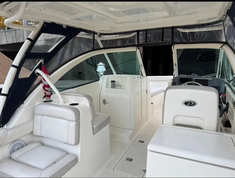 Slide: The Image of 2014 Pursuit DC 265 Dual Console boat interior with seating and helm. - 10