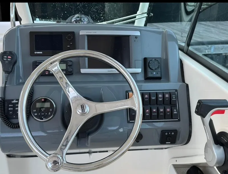 Slide: The Image of 2014 Pursuit DC 265 Dual Console helm with steering wheel and control panel. - 14