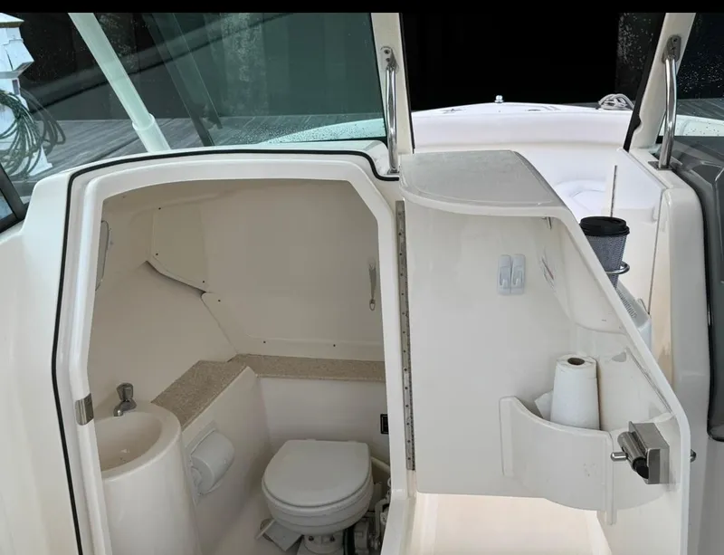 Slide: The Image of 2014 Pursuit DC 265 Dual Console boat interior with compact bathroom amenities. - 16