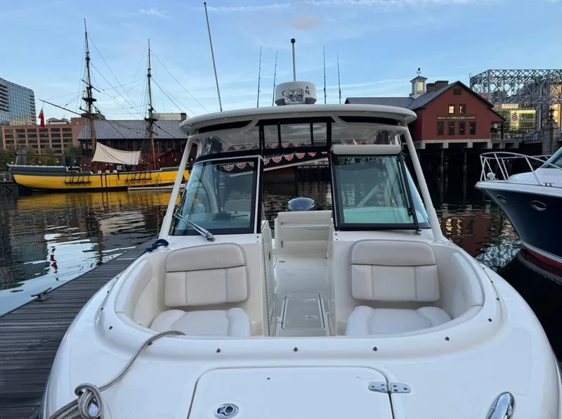 Slide: The Image of 2014 Pursuit DC 265 Dual Console boat docked in scenic harbor. - 19