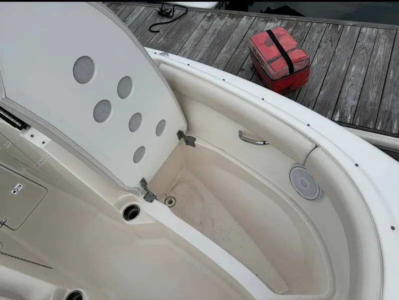 Slide: The Image of 2014 Pursuit DC 265 Dual Console boat interior with storage compartment open. - 21