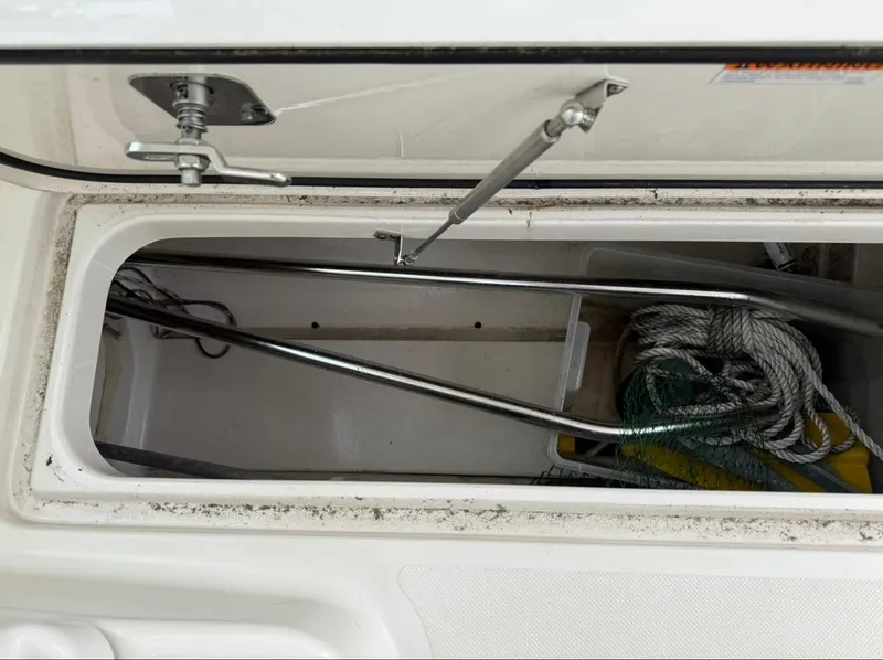 Slide: The Image of Storage compartment of 2014 Pursuit DC 265 Dual Console boat with ropes and equipment. - 22