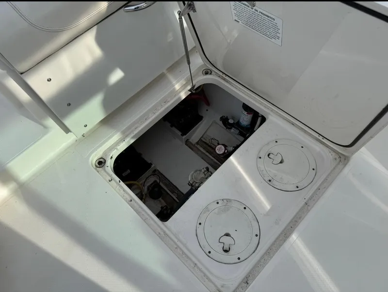 Slide: The Image of Open hatch on 2014 Pursuit DC 265 Dual Console boat, revealing storage compartment. - 24