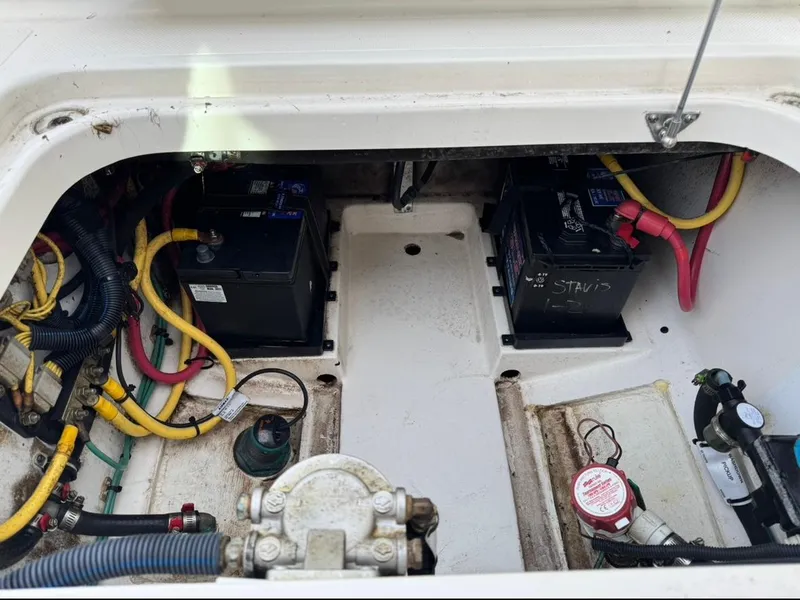 Slide: The Image of 2014 Pursuit DC 265 Dual Console boat battery compartment with wiring and components. - 25
