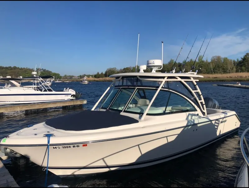 Slide: The Image of 2014 Pursuit DC 265 Dual Console boat docked on a sunny day. - 26