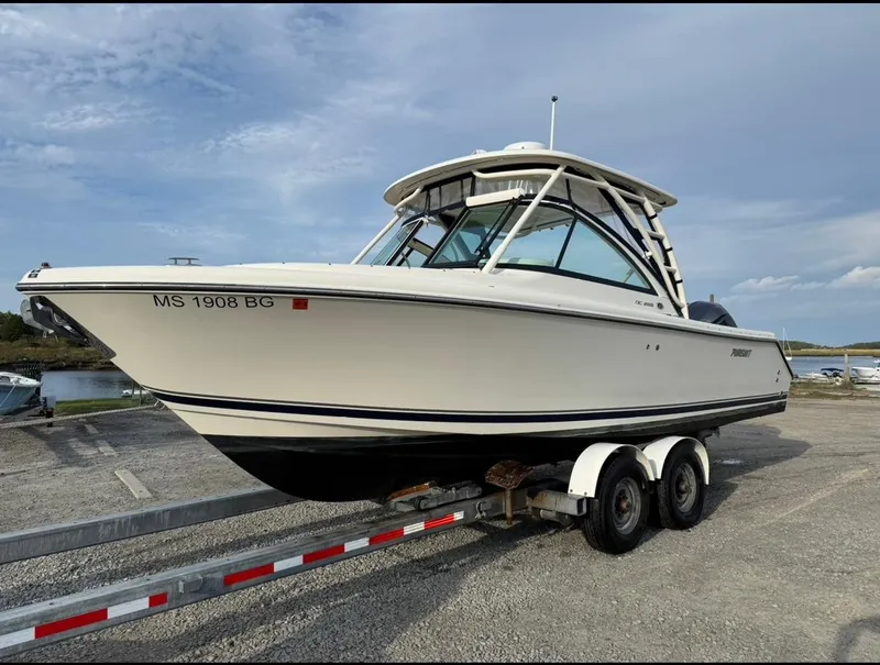 Slide: The Image of 2014 Pursuit DC 265 Dual Console boat on trailer, parked outdoors. - 27