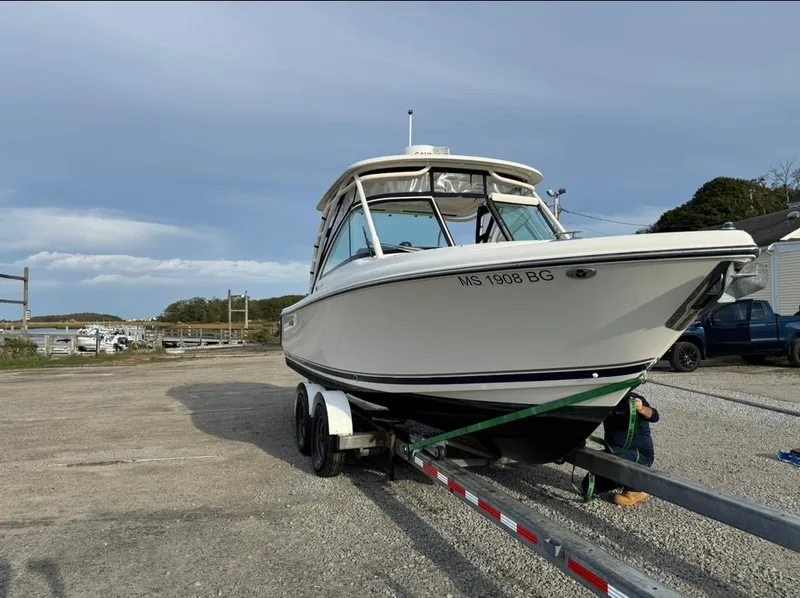 Slide: The Image of 2014 Pursuit DC 265 Dual Console boat on trailer in outdoor setting. - 28