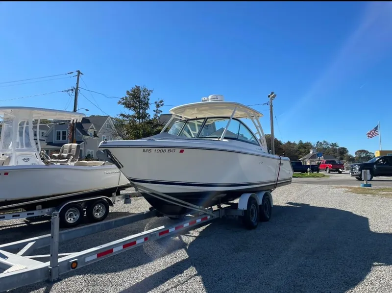 Slide: The Image of 2014 Pursuit DC 265 Dual Console boat on trailer in sunny outdoor setting. - 29