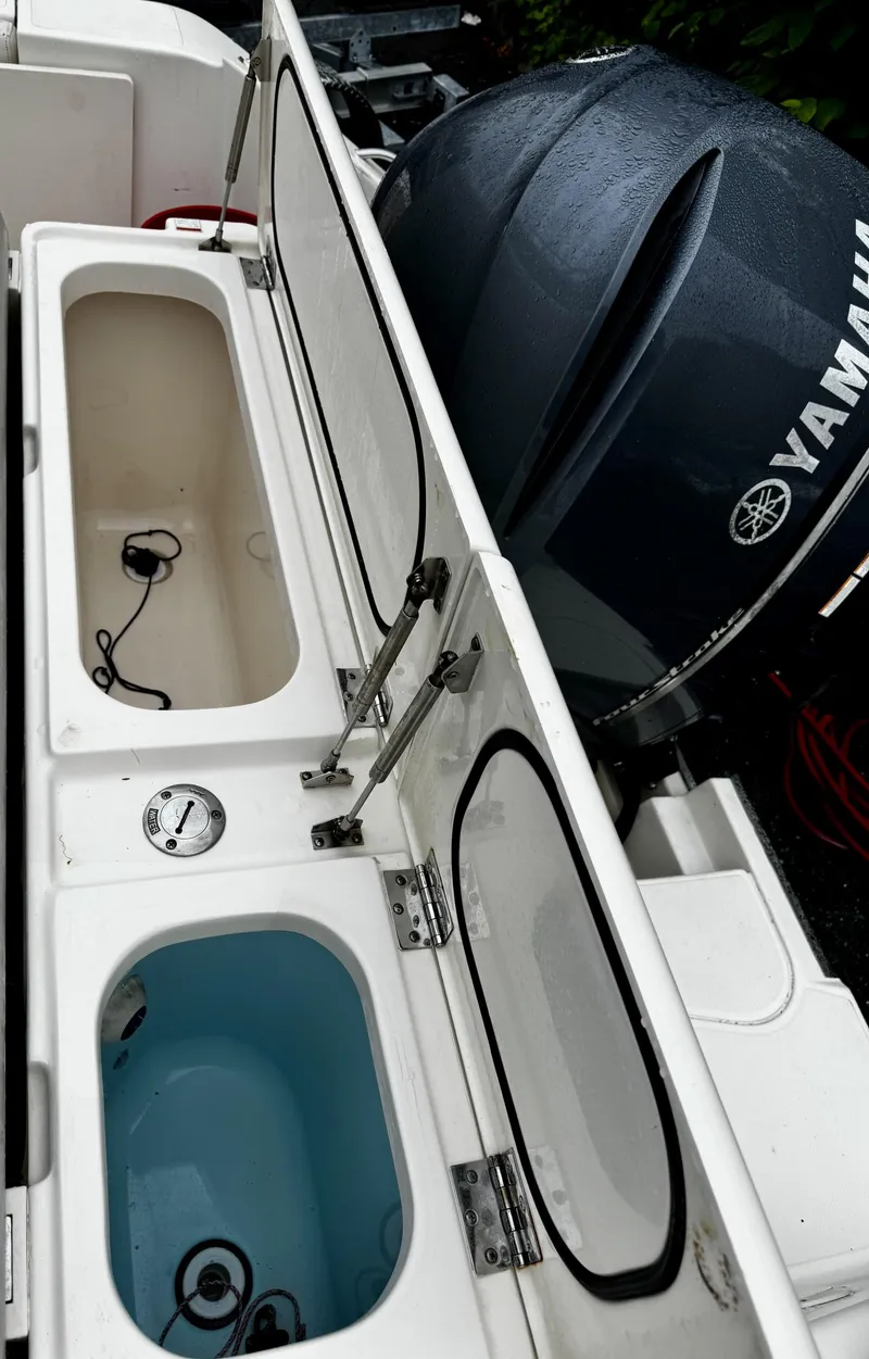 Slide: The Image of 2014 Pursuit DC 265 Dual Console boat with open storage compartments and Yamaha engine. - 5