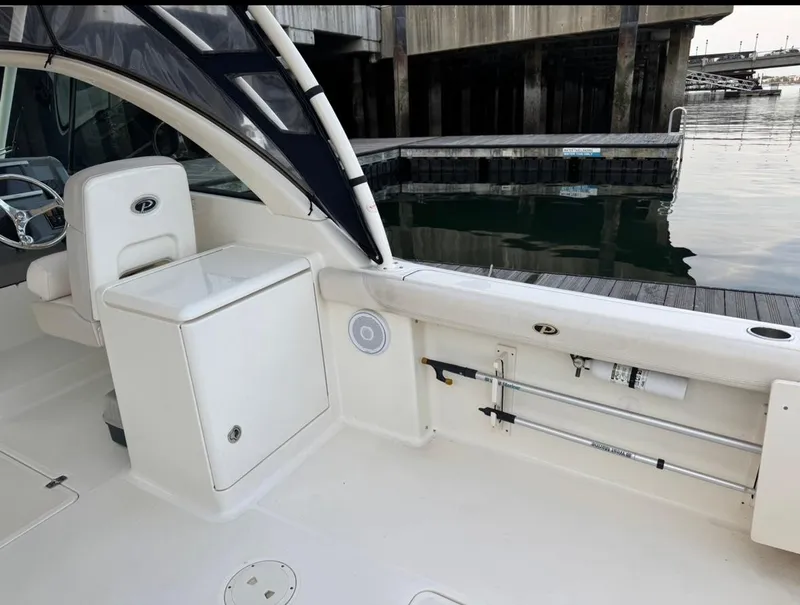 Slide: The Image of 2014 Pursuit DC 265 Dual Console boat interior near dock. - 8