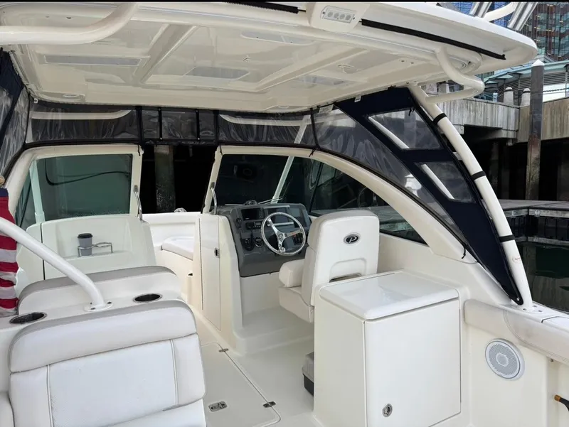 Slide: The Image of 2014 Pursuit DC 265 Dual Console boat interior with white seating and steering console. - 9