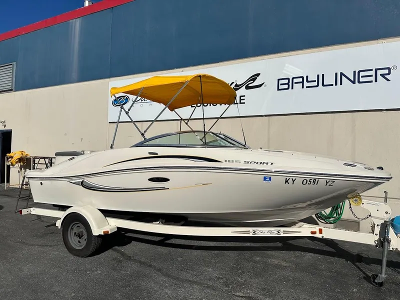 Slide: The Image of 2008 Sea Ray 185 Sport boat with yellow canopy on trailer, parked outside dealership. - 3