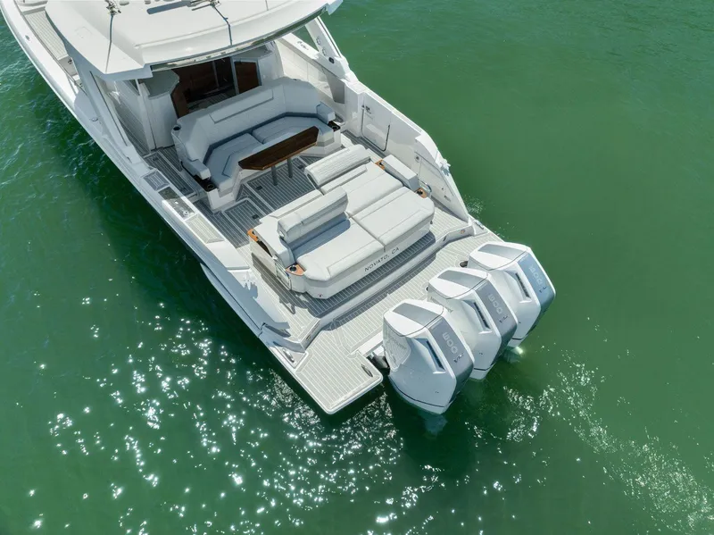 Slide: The Image of 2024 Tiara Yachts 48 LS with triple outboard engines on calm water. - 12