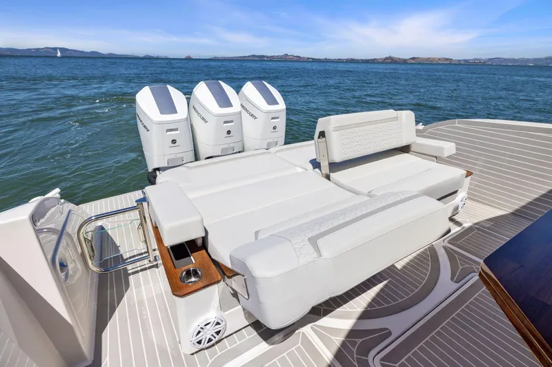 Slide: The Image of 2024 Tiara Yachts 48 LS luxury boat with spacious seating and triple engines on open water. - 15