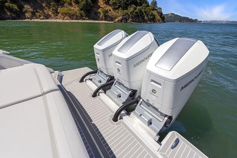 Slide: The Image of 2024 Tiara Yachts 48 LS with triple Mercury outboard engines on a serene lake. - 19