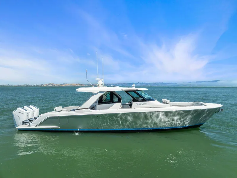Slide: The Image of 2024 Tiara Yachts 48 LS cruising on open water under clear blue skies. - 2