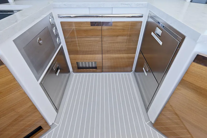 Slide: The Image of 2024 Tiara Yachts 48 LS kitchen with modern appliances and wood accents. - 26