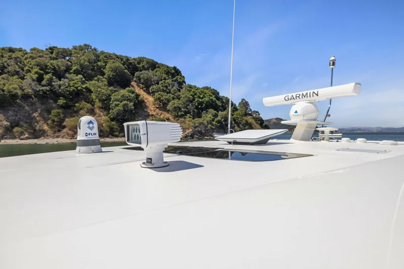 Slide: The Image of 2024 Tiara Yachts 48 LS with Garmin radar, docked near lush greenery. - 33