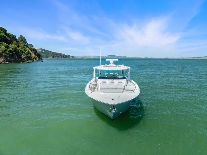 Slide: The Image of 2024 Tiara Yachts 48 LS on serene green water under blue sky. - 4