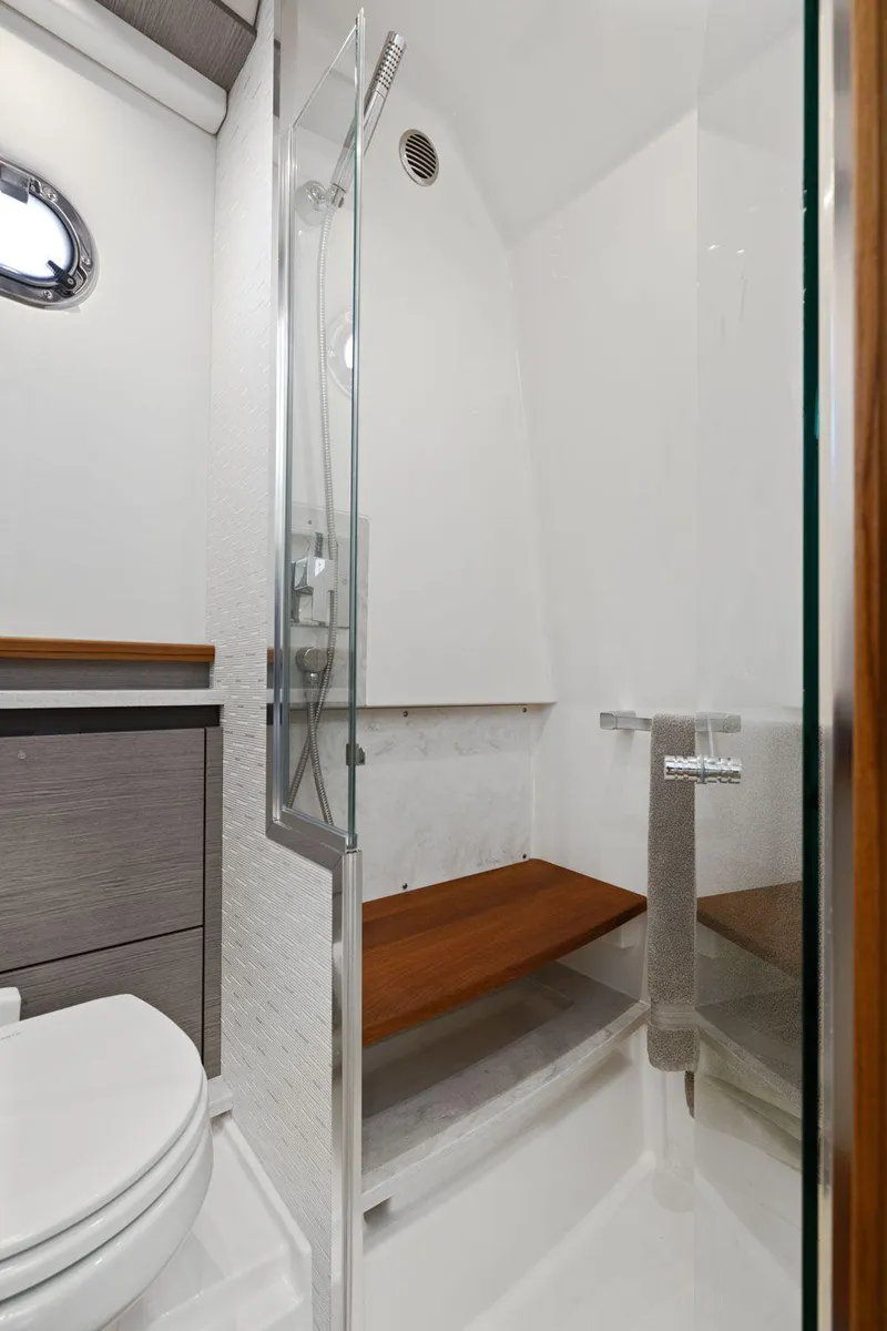 Slide: The Image of 2024 Tiara Yachts 48 LS bathroom with modern shower and wooden accents. - 46