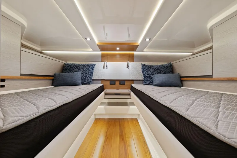 Slide: The Image of Luxurious 2024 Tiara Yachts 48 LS cabin interior with twin beds and modern lighting. - 48