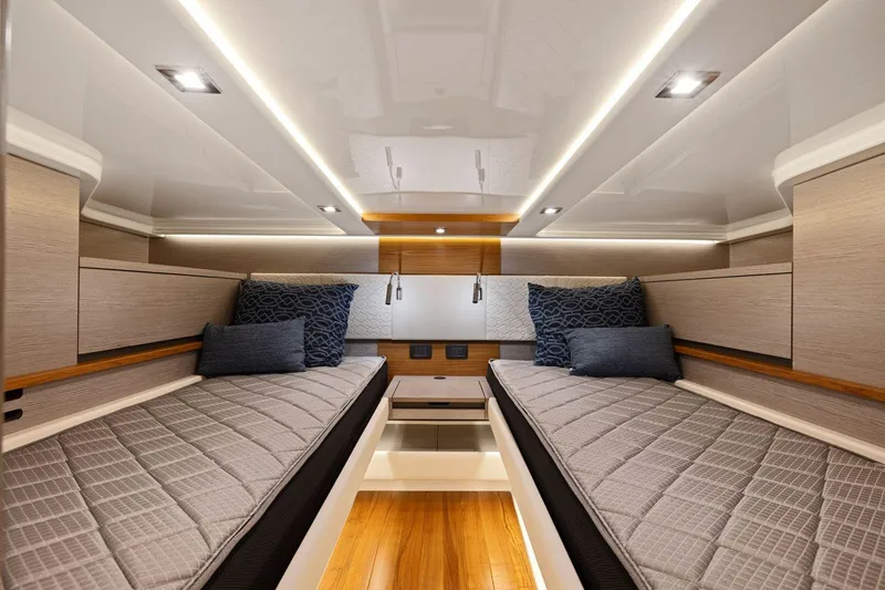 Slide: The Image of Luxurious 2024 Tiara Yachts 48 LS cabin interior with twin beds and modern lighting. - 49