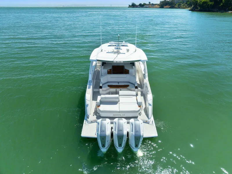 Slide: The Image of 2024 Tiara Yachts 48 LS on serene water, showcasing sleek design and triple engines. - 9