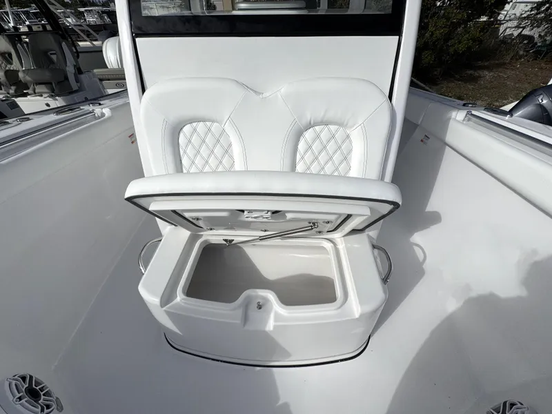 Slide: The Image of 2025 Sportsman Open 302 boat with open storage compartment and white cushioned seating. - 16