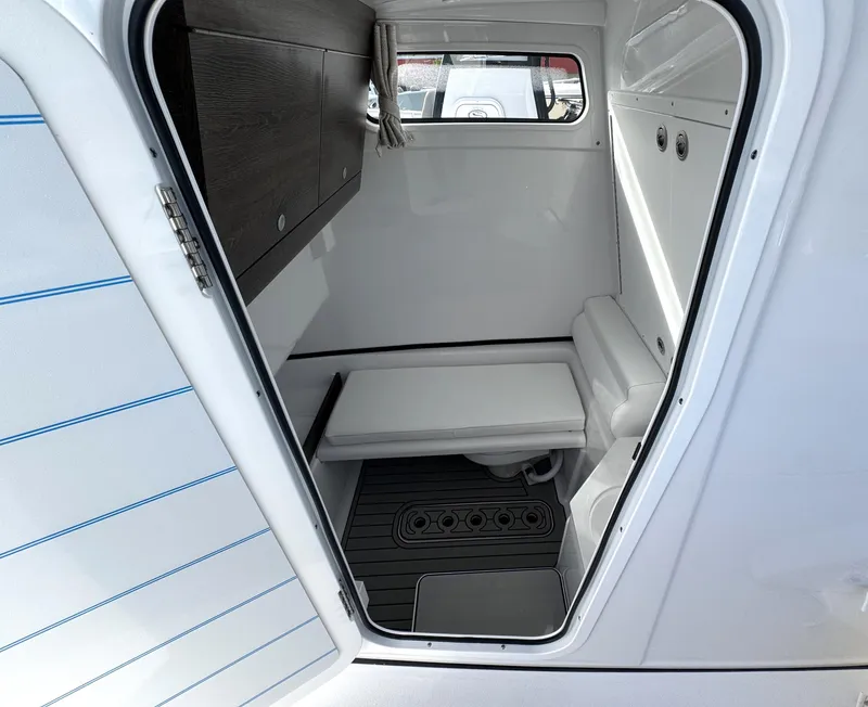 Slide: The Image of 2025 Sportsman Open 302 boat cabin interior with seating and storage. - 17