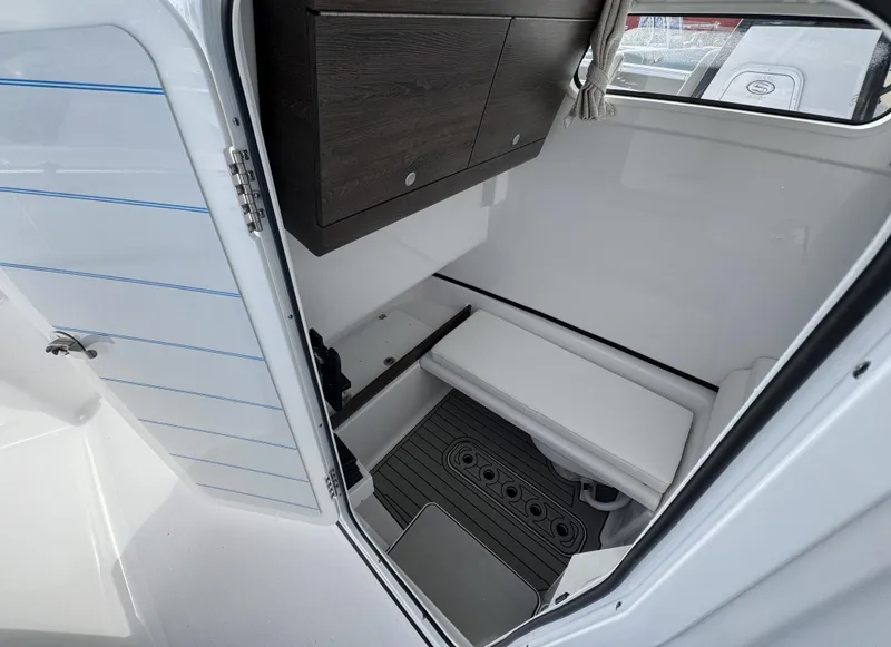 Slide: The Image of 2025 Sportsman Open 302 boat interior with storage and seating area. - 18