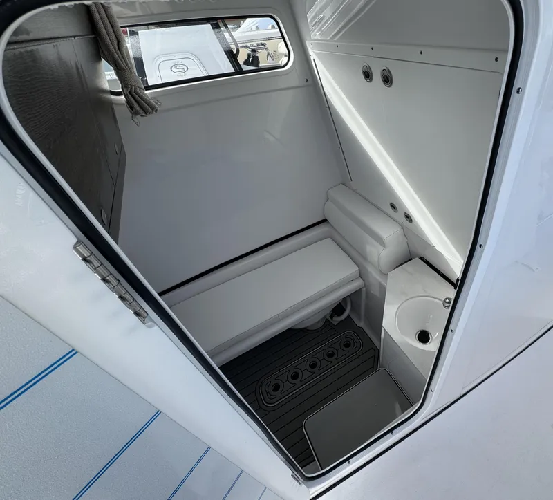 Slide: The Image of Interior of 2025 Sportsman Open 302 boat cabin with compact bathroom. - 19