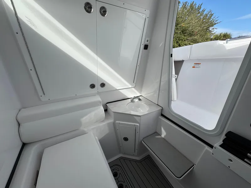 Slide: The Image of Interior of 2025 Sportsman Open 302 boat, featuring a compact sink and seating area. - 20