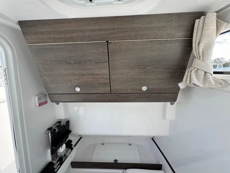 Slide: The Image of Interior cabin of 2025 Sportsman Open 302 boat with wooden cabinets. - 21