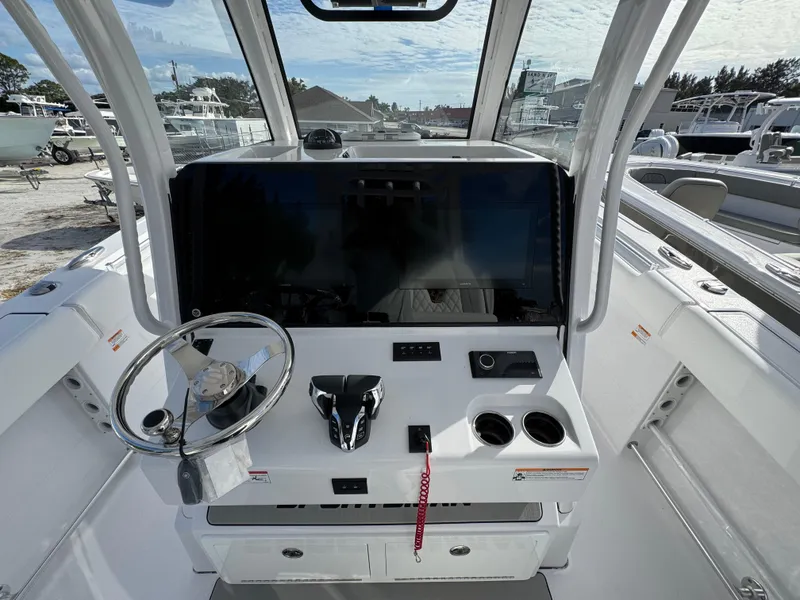 Slide: The Image of 2025 Sportsman Open 302 boat dashboard with steering wheel and controls. - 27