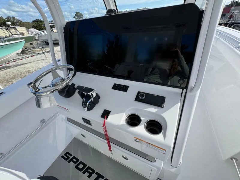 Slide: The Image of 2025 Sportsman Open 302 boat dashboard with steering wheel and controls. - 28