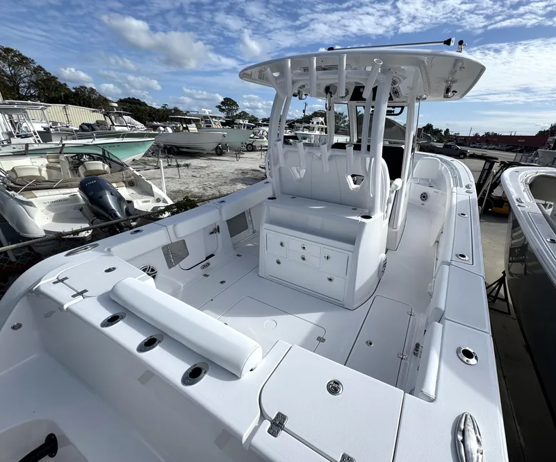 Slide: The Image of 2025 Sportsman Open 302 boat with spacious deck and seating, docked under a blue sky. - 3