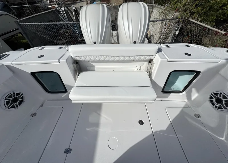 Slide: The Image of 2025 Sportsman Open 302 boat interior with white seating and storage compartments. - 38