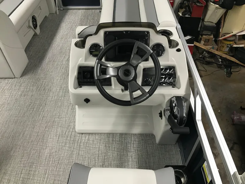 Slide: The Image of 2025 Avalon Venture Cruise Rear Bench boat dashboard with steering wheel and controls. - 13