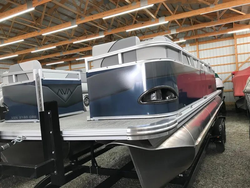Slide: The Image of 2025 Avalon Venture Cruise Rear Bench pontoon boat in a storage facility. - 19