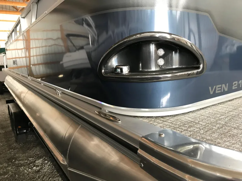 Slide: The Image of 2025 Avalon Venture Cruise Rear Bench pontoon boat, close-up of sleek blue exterior and railing. - 21